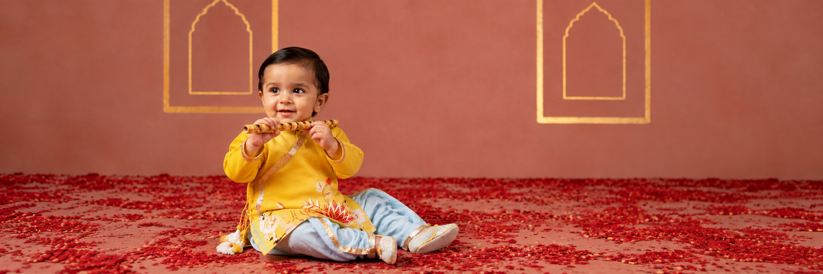 Toddler in traditional Indian outfit holding a flute